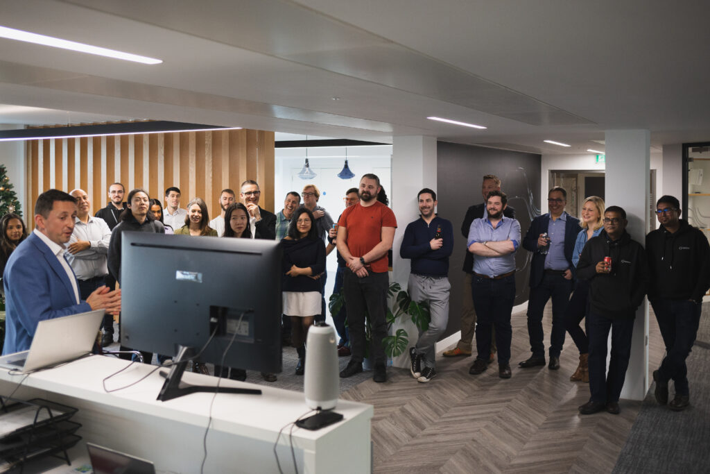 The Optalysys team attending an all-hands meeting, listening as CEO Nick New presents.
